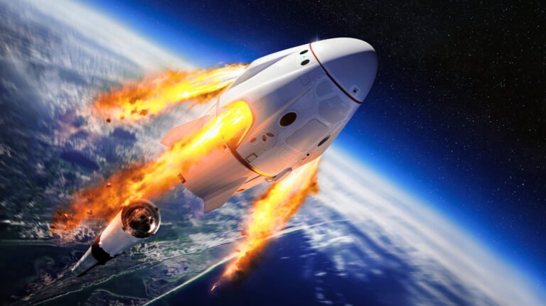 Statek kosmiczny SpaceX Dragon w fazie startu z Ziemi, otoczony ogniem i dymem, przelatujący przez atmosferę w stronę przestrzeni kosmicznej.