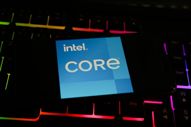 Smartfon z logo Intel Core na tle podświetlanej klawiatury.