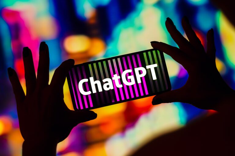 Osoba trzymająca smartfon z napisem "ChatGPT" na tle kolorowych świateł.