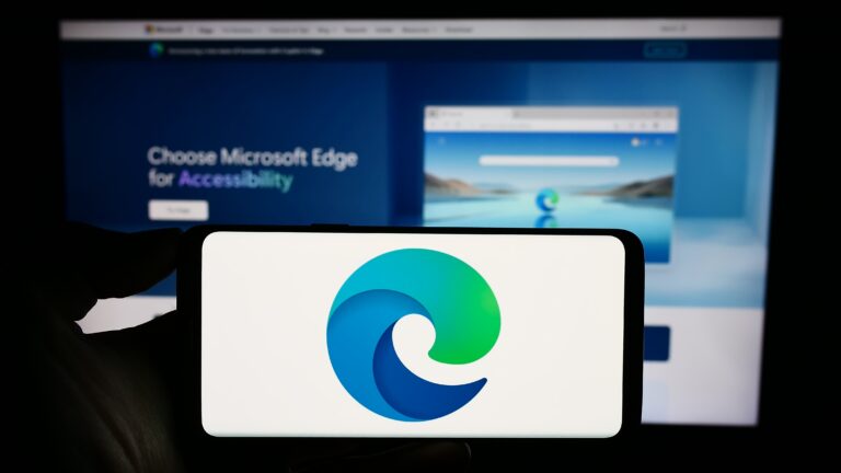 Logo Microsoft Edge na ekranie smartfona, w tle strona internetowa promująca przeglądarkę.
