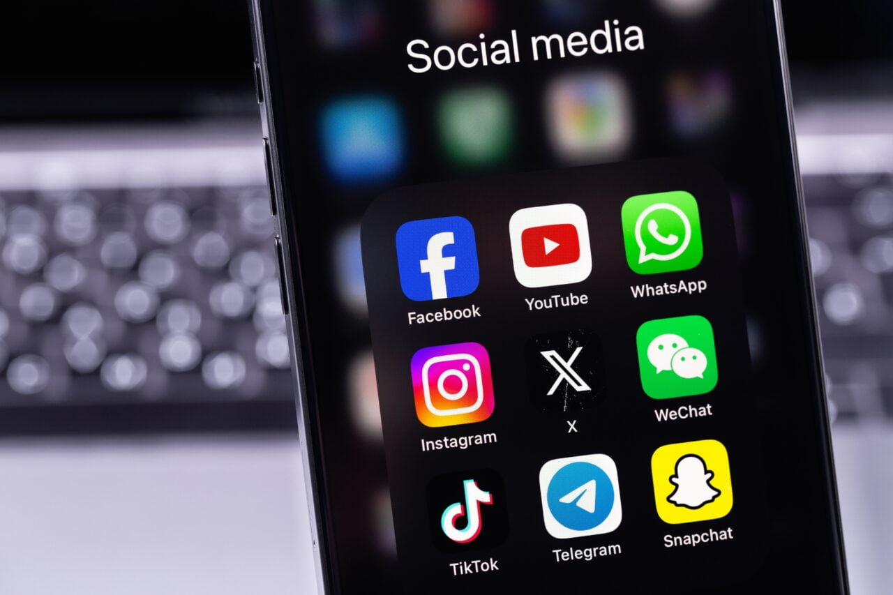 Ekran smartfona z ikonami aplikacji mediów społecznościowych: Facebook, YouTube, WhatsApp, Instagram, serwis X, WeChat, TikTok, Telegram, Snapchat.