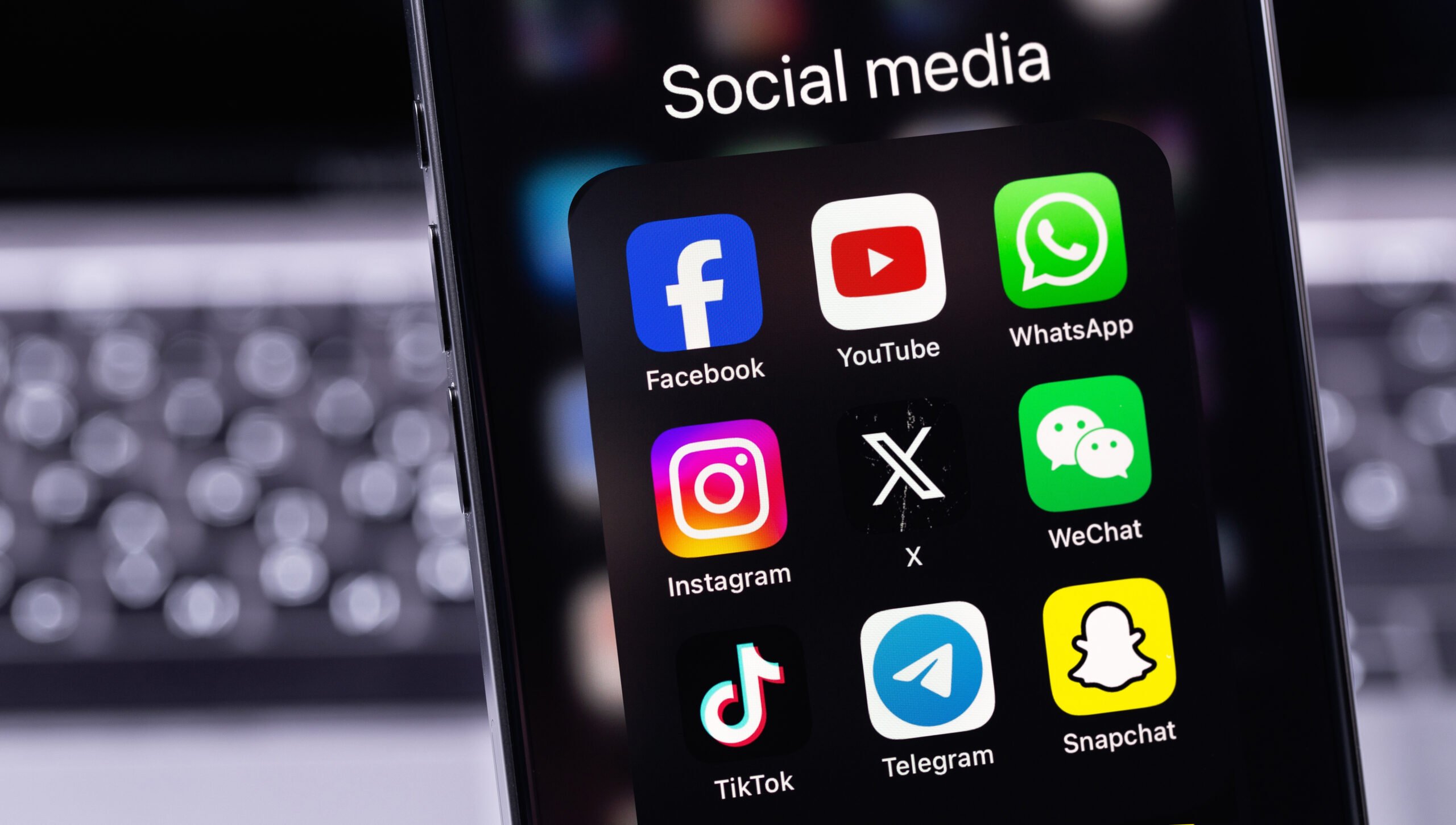 Ikony aplikacji mediów społecznościowych na ekranie smartfona, w tym Facebook, YouTube, WhatsApp, Instagram, X, WeChat, TikTok, Telegram i Snapchat.