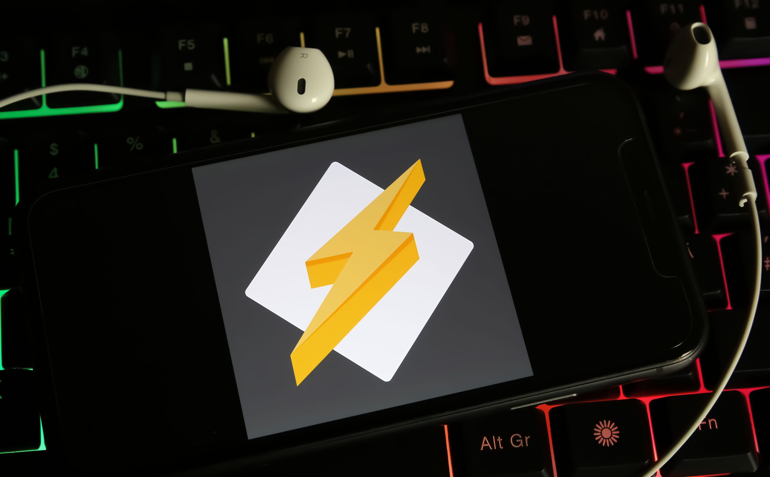 Logo Winamp na ekranie smartfona, tło to klawiatura komputerowa.