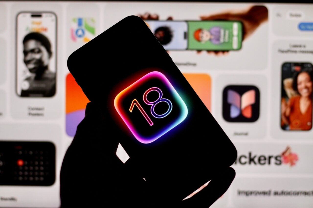 Funkcje AI w iOS 18.  Czarna sylwetka telefonu z logo iOS 18 na tle ekranu z aplikacjami.
