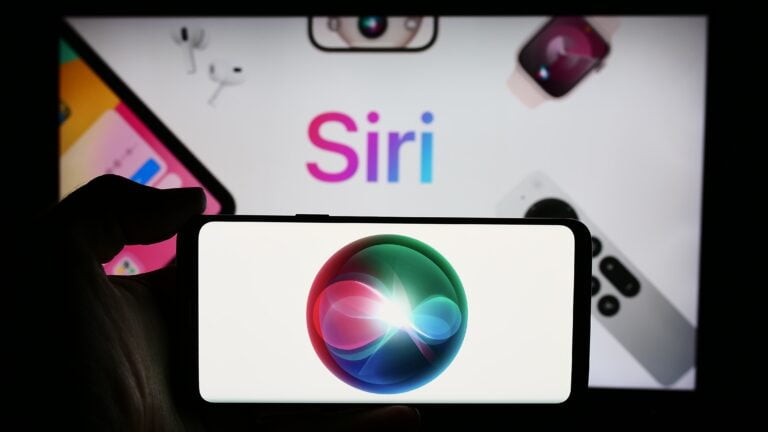 Telefon z logo Siri na ekranie, w tle inne urządzenia Apple i napis "Siri".