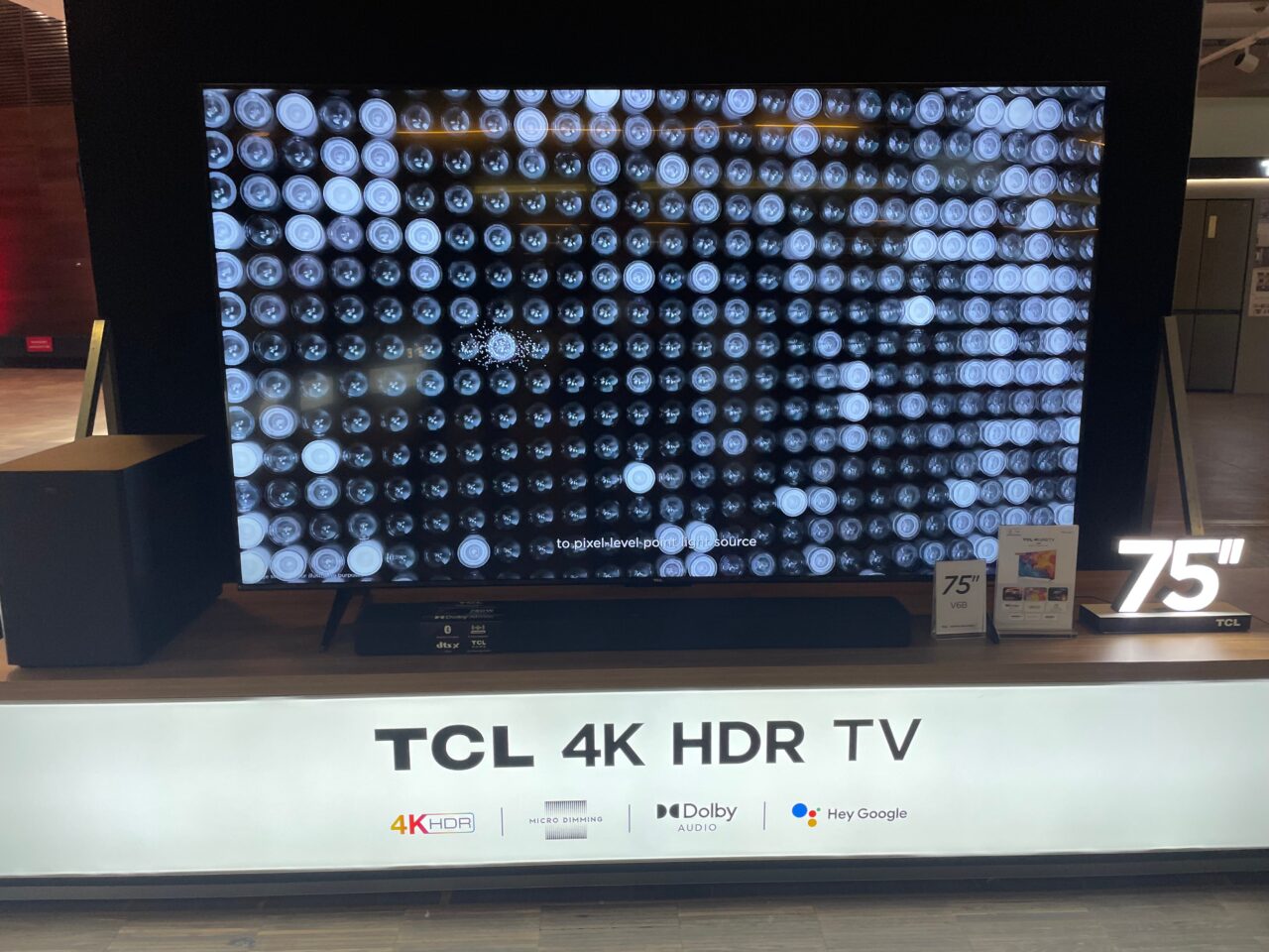 75-calowy telewizor TCL 4K HDR na wystawie, z ekranem wyświetlającym abstrakcyjny wzór.