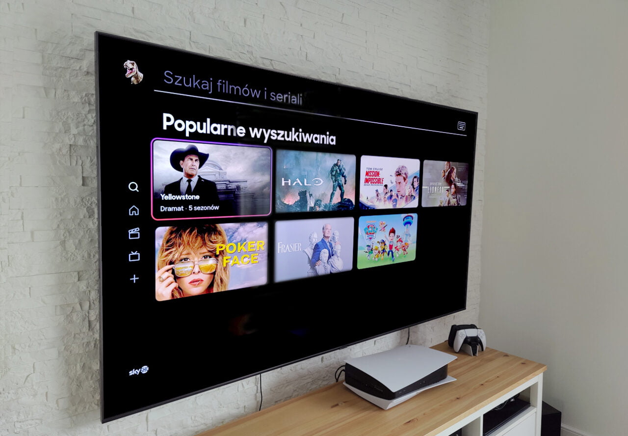 Reklamy w streamingu. Telewizor na ścianie wyświetlający ekran menu z aplikacjami streamingowymi w nowoczesnym salonie.