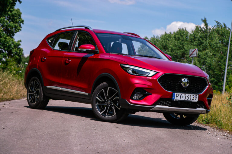 Czerwony samochód SUV marki MG, model ZS, podczas test MG ZS na drodze w słoneczny dzień.