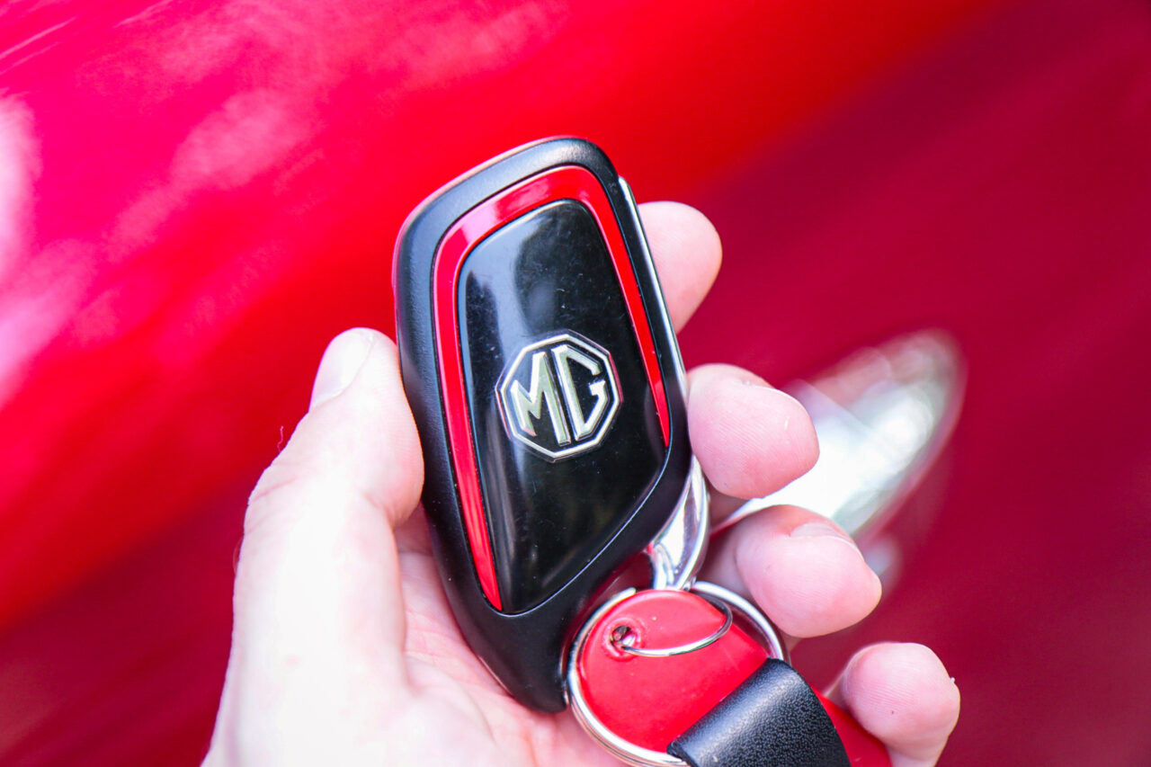 Kluczyk samochodowy MG na tle czerwonego lakieru podczas testu MG ZS.