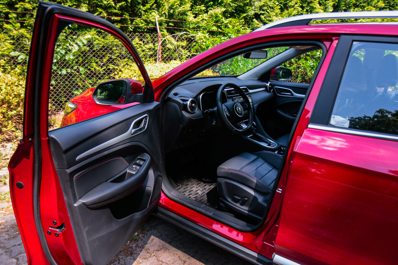 Wnętrze samochodu test MG ZS, widok na otwarte drzwi kierowcy oraz kokpit.