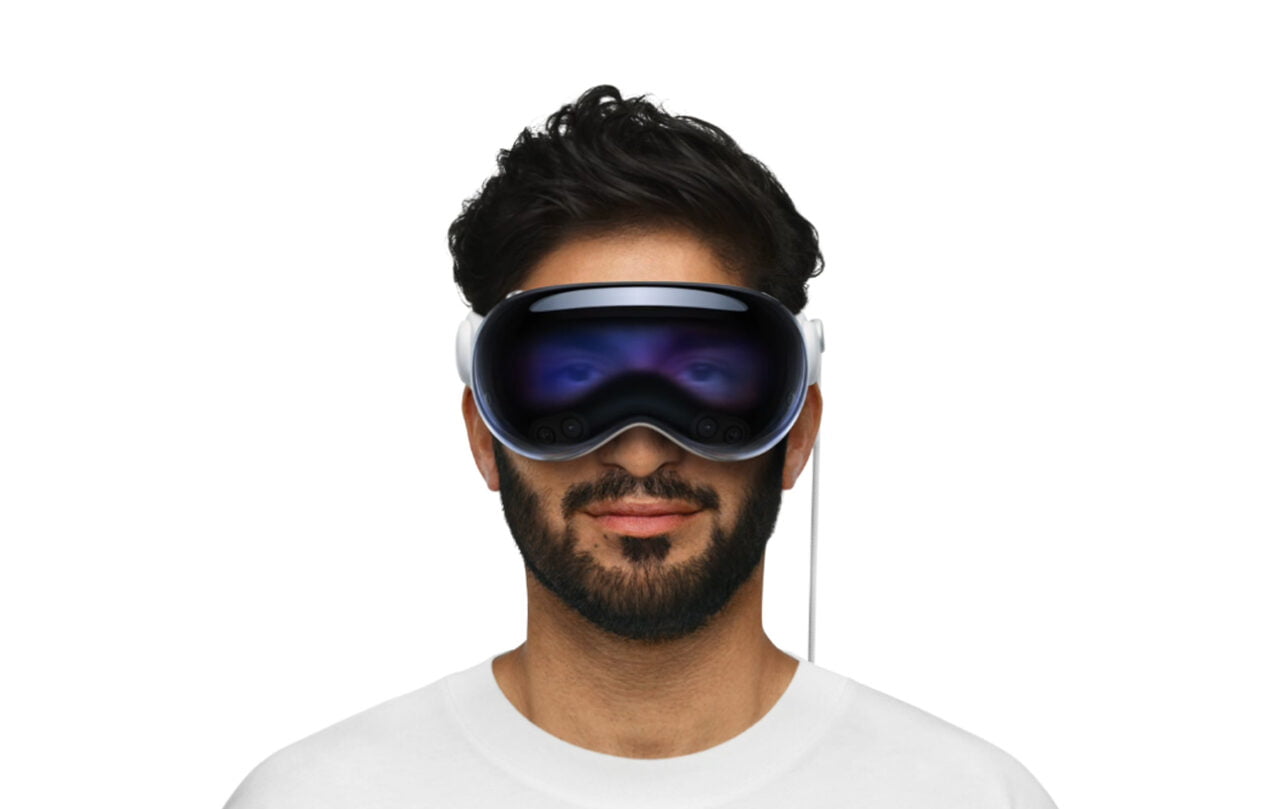 Osoba nosząca okulary Apple Vision Pro, ubrana w biały T-shirt.