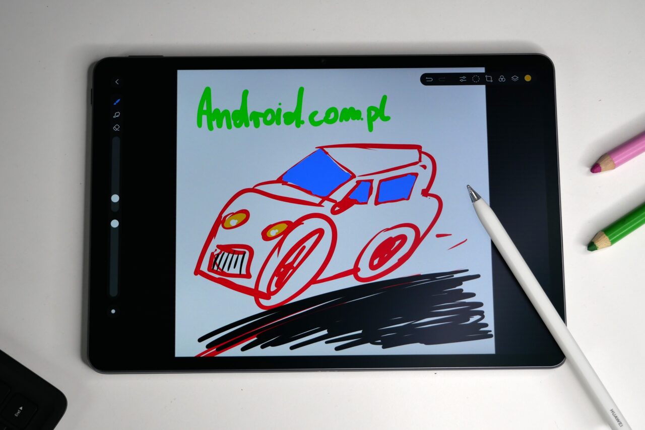 Rysunek samochodu na tablecie z napisem "Android.com.pl" na górze ekranu.
