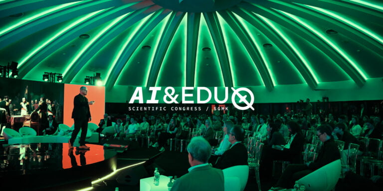 Osoba przemawiająca na scenie podczas konferencji AI & EDU Scientific Congress, w futurystycznie oświetlonym audytorium z publicznością.