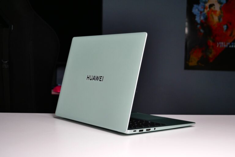 Jasnozielony laptop Huawei na białym biurku.