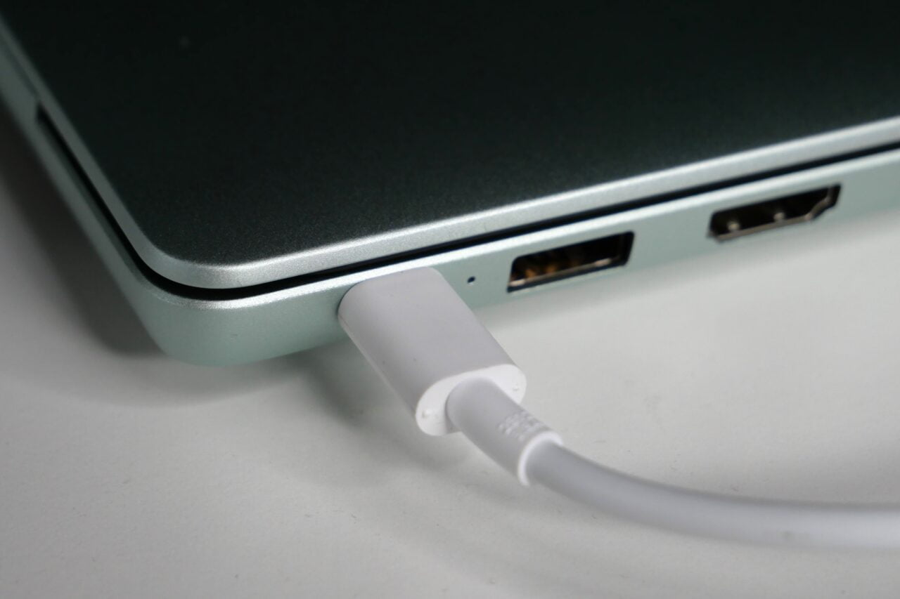 Kabel USB-C podłączony do laptopa obok portu HDMI.