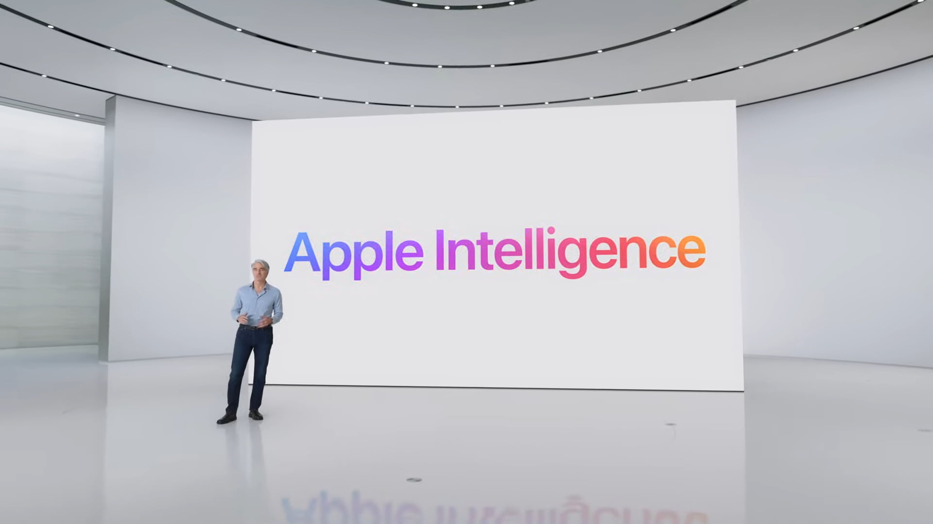 Mężczyzna stojący na scenie z napisem "Apple Intelligence" na dużym ekranie za nim.
