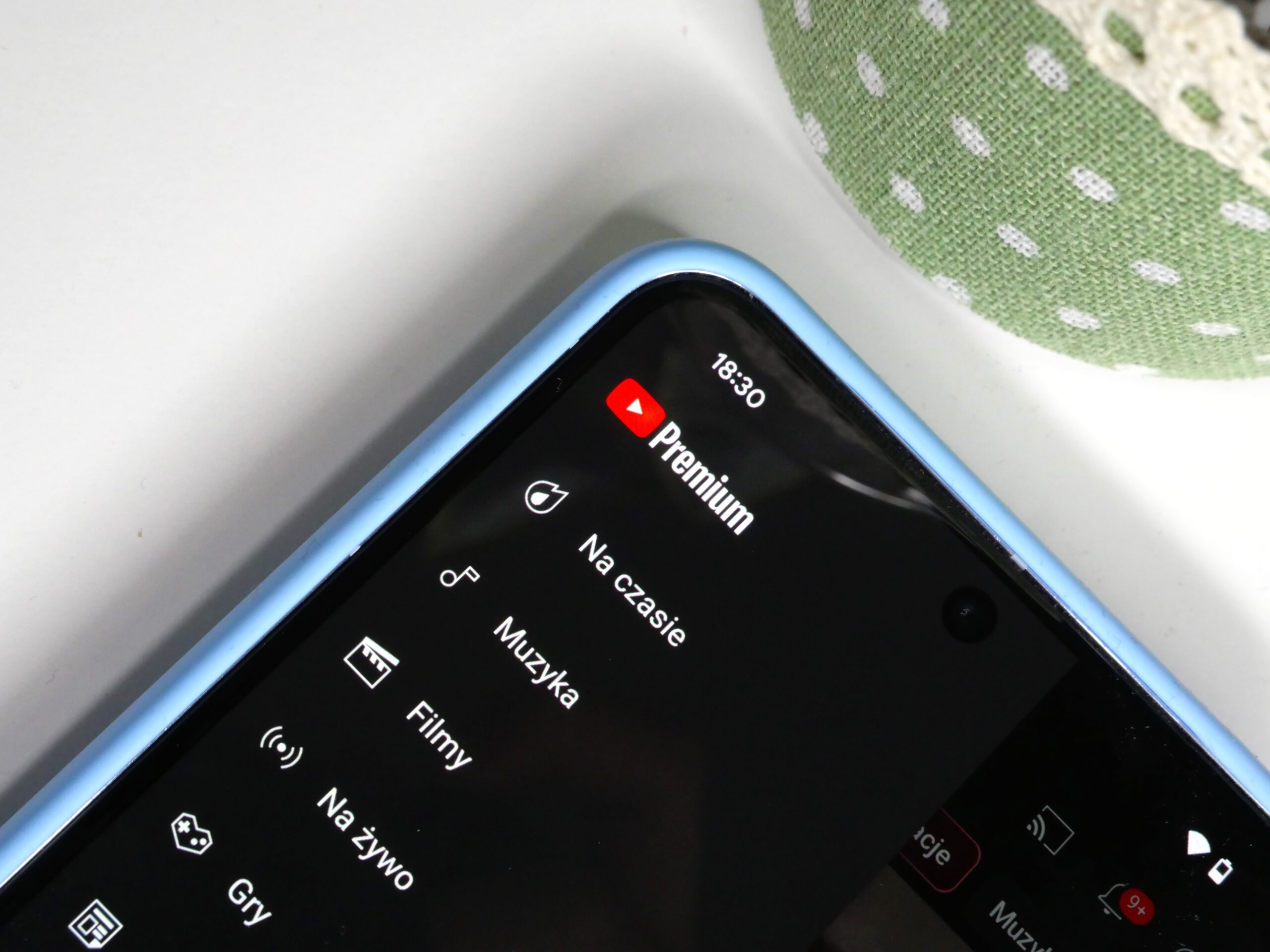 Ekran telefonu z aplikacją YouTube Premium, widoczne ikony kategorii i godzina 18:30.