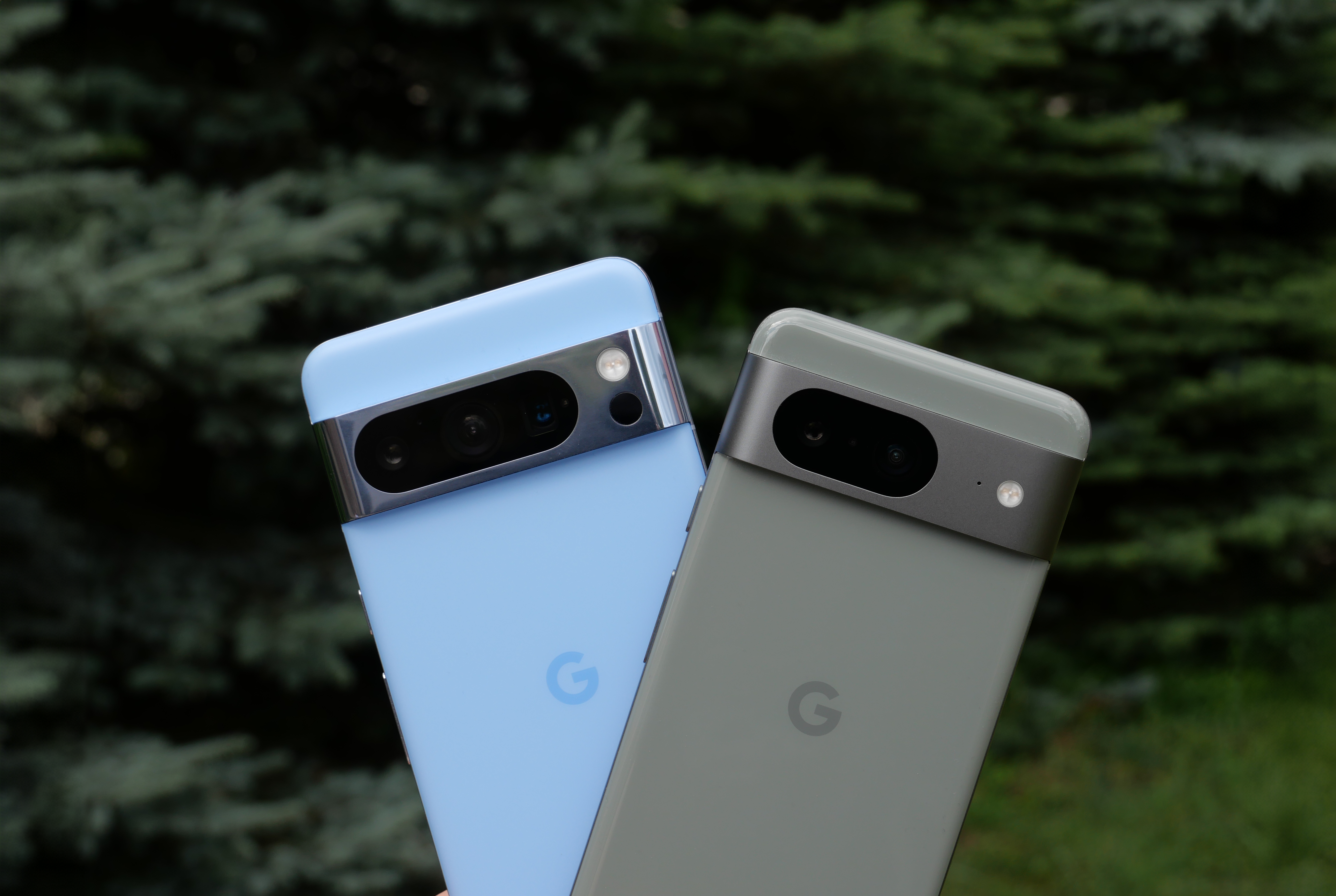 Dwa smartfony Google Pixel 8 i Pixel 8 Pro w kolorach jasnozielonym i niebieskim na tle zieleni.