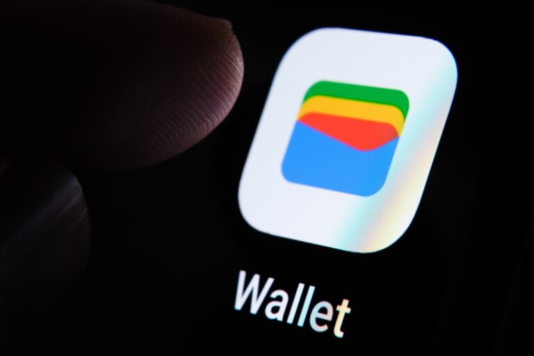 Ikona aplikacji Google Wallet na ekranie smartfona, przy której widać palec użytkownika.