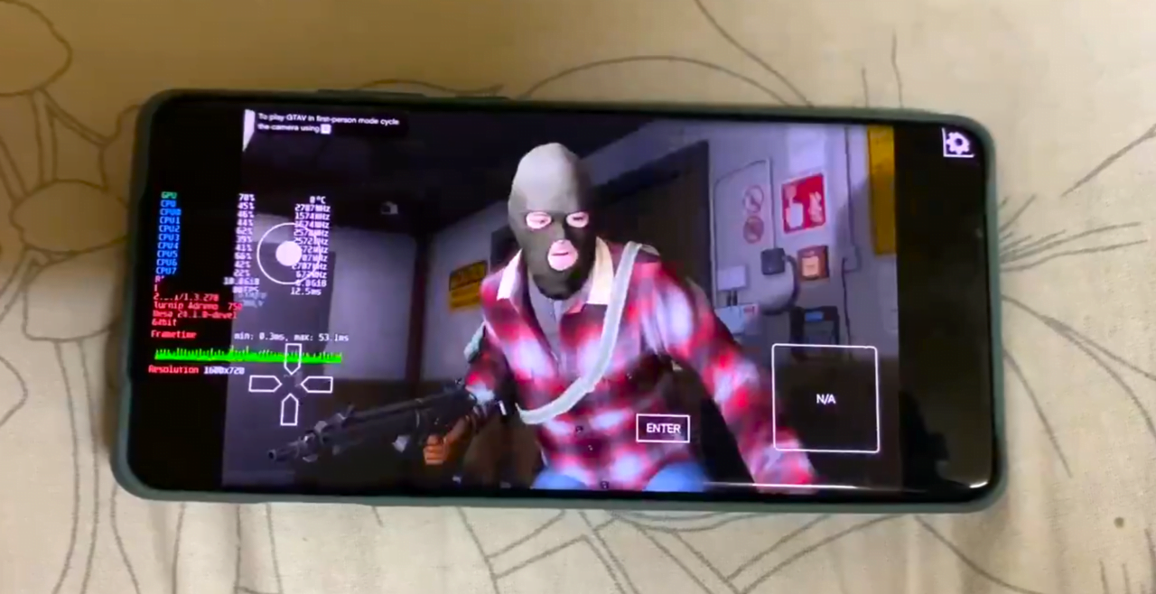 Gra komputerowa wyświetlana na ekranie smartfona, przedstawiająca postać w kominiarce z bronią, z panelami kontrolnymi CPU i GPU po lewej stronie ekranu.