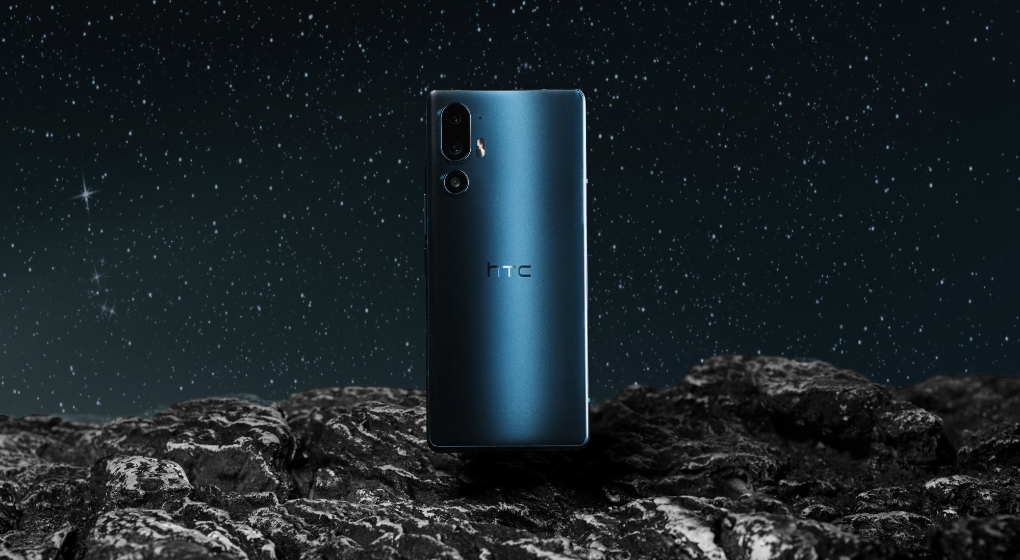 Smartfon HTC U24 Pro na tle nocnego nieba pełnego gwiazd.