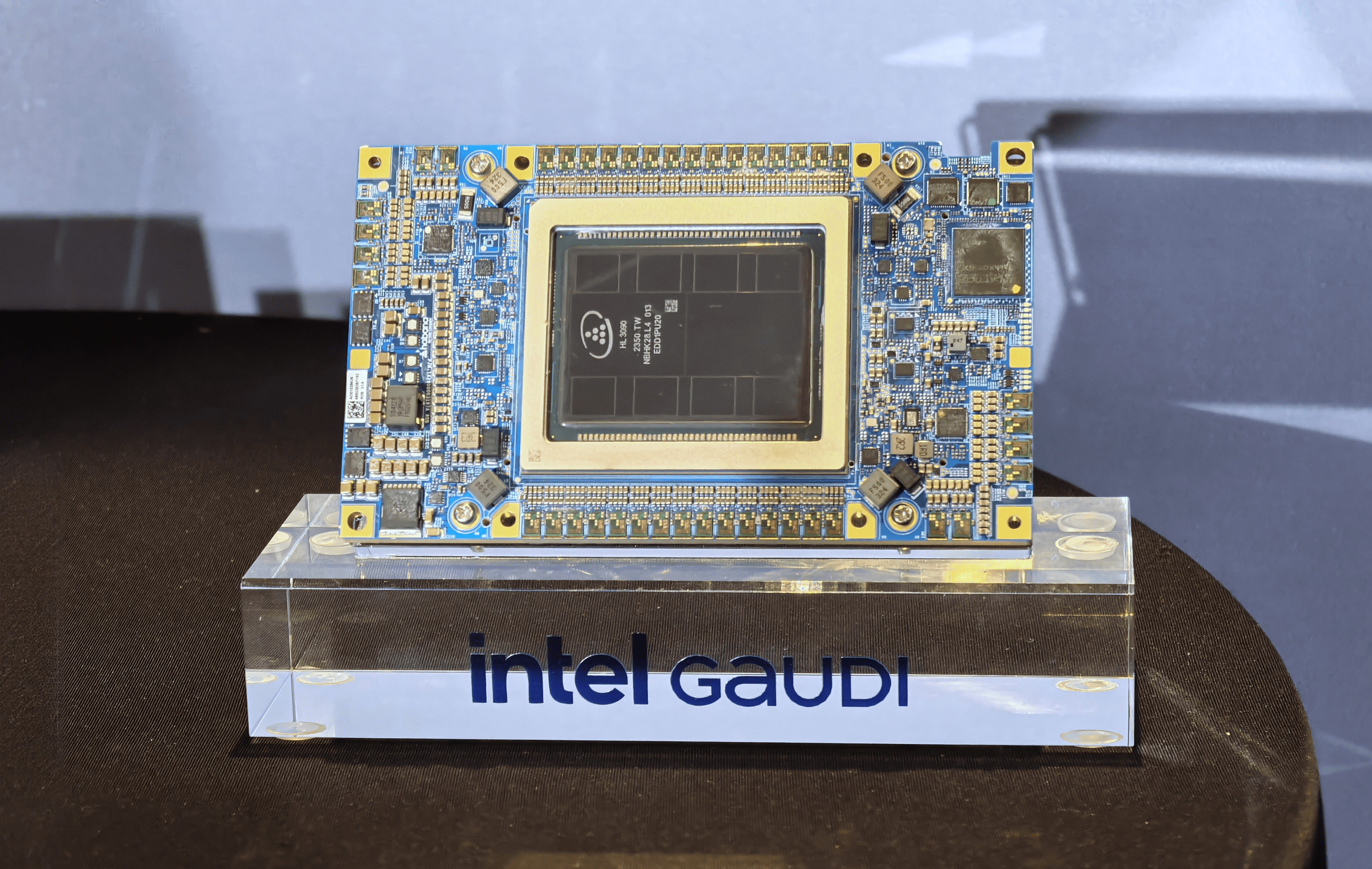 Układ scalony Intel Gaudi umieszczony na przezroczystej podstawce z nazwą "intel GAUDI".