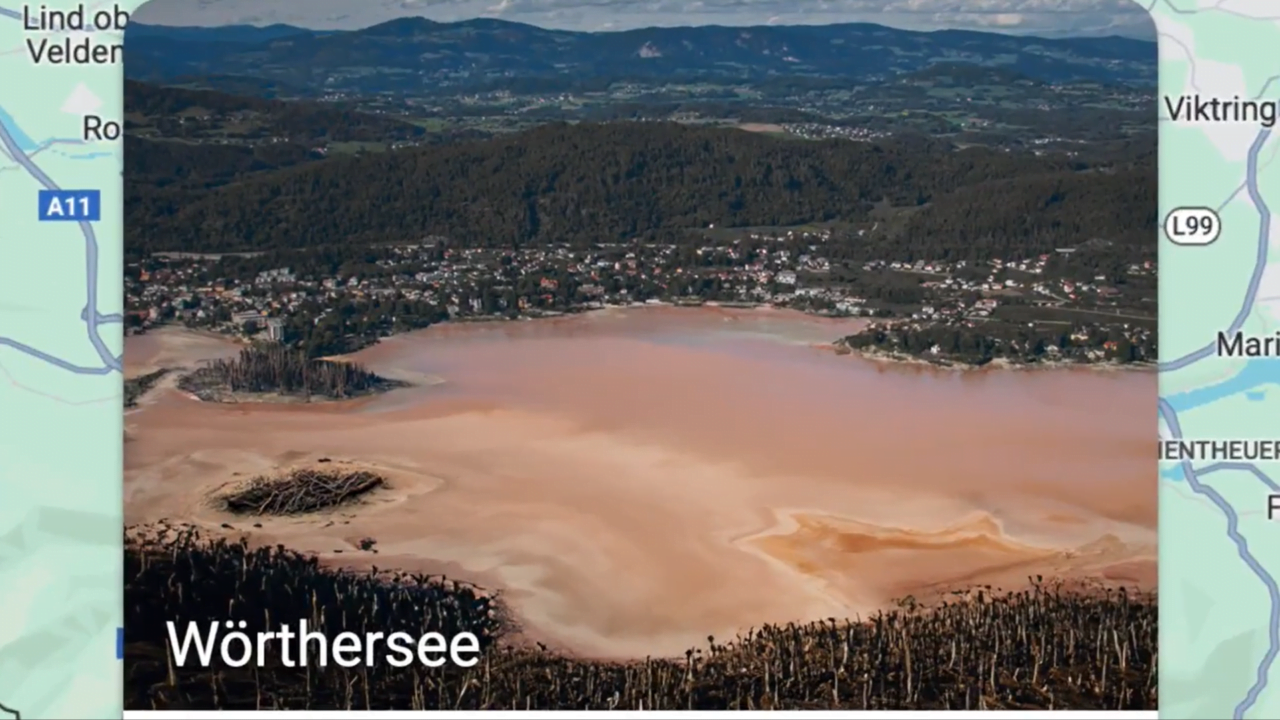 Jezioro Wörthersee w Google Maps otoczone górzystym krajobrazem z domami na brzegu.