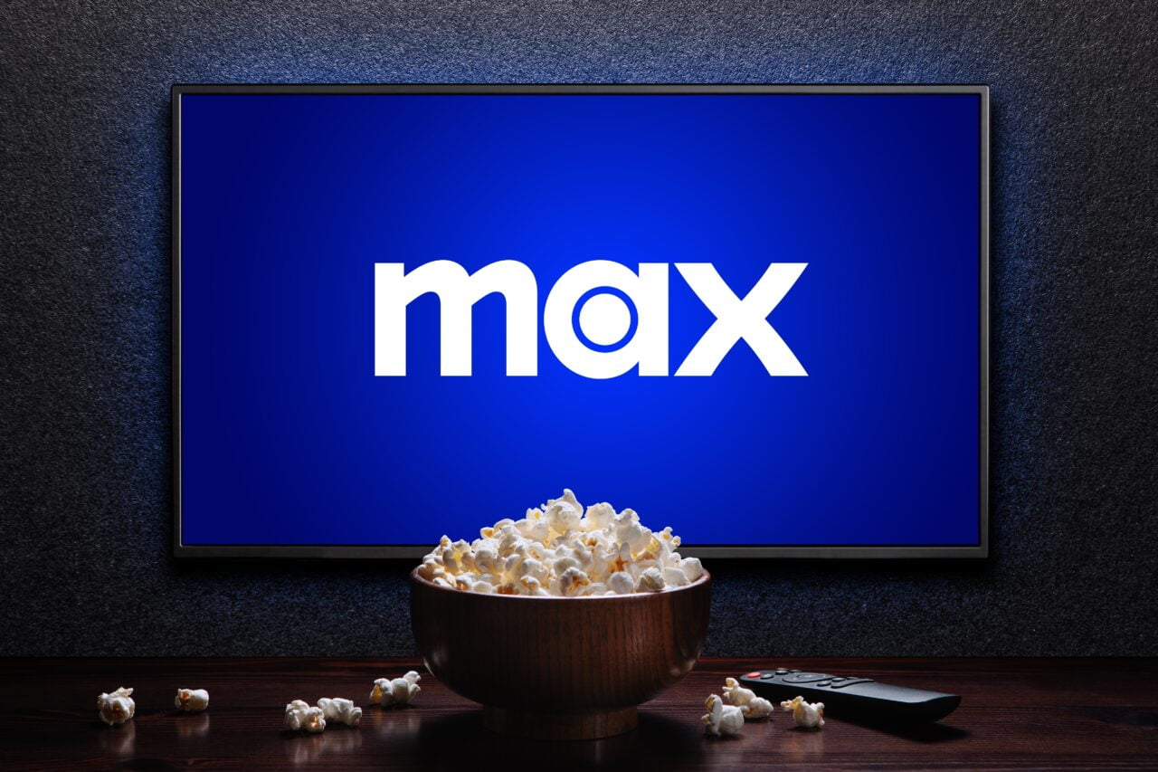 Telewizor z logo "max" na ekranie, miska popcornu i pilot na stole.