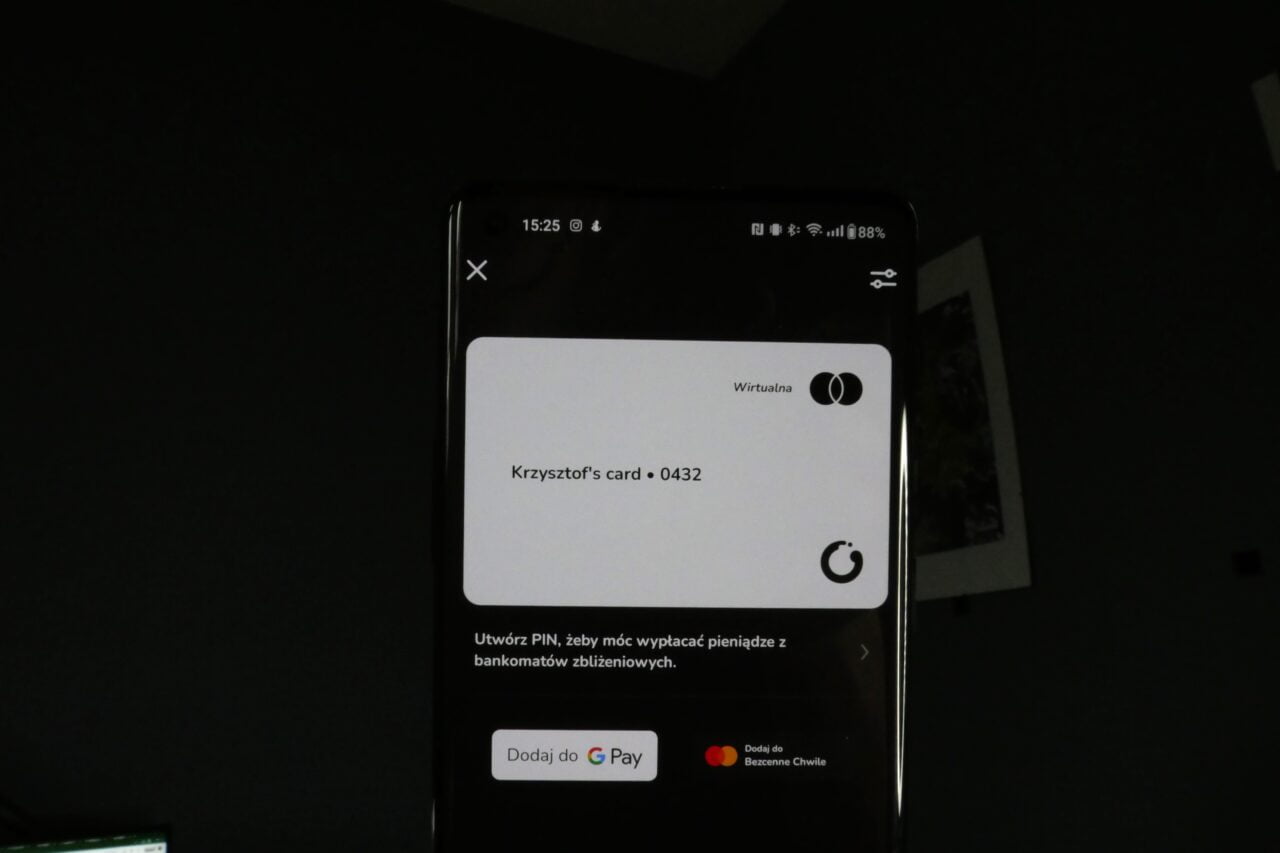 Telefon komórkowy ukazujący wirtualną kartę płatniczą z nazwą "Krzysztof's card 0432".