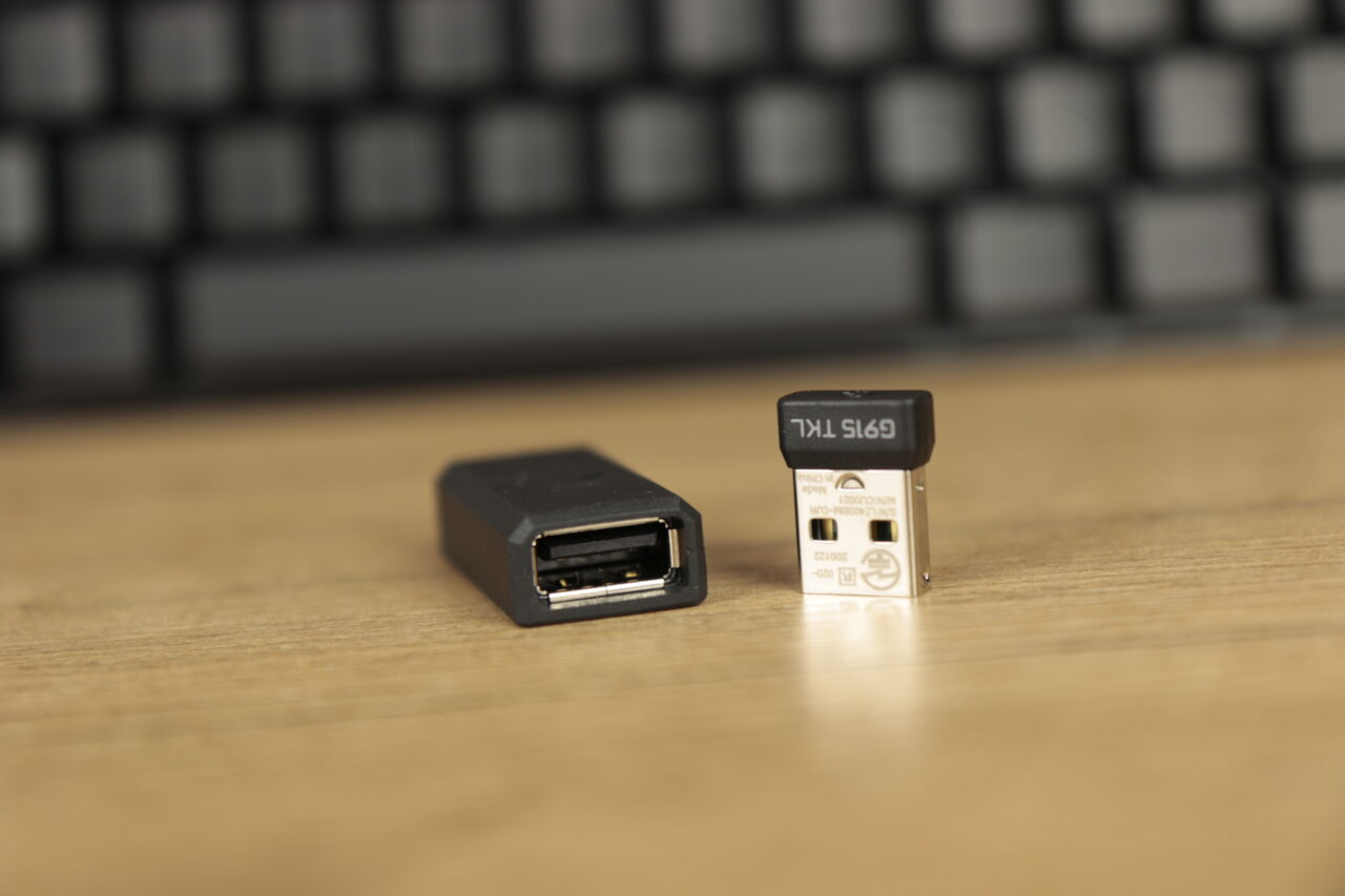 Recenzja Logitech G915 TKL - adaptery USB na tle klawiatury.