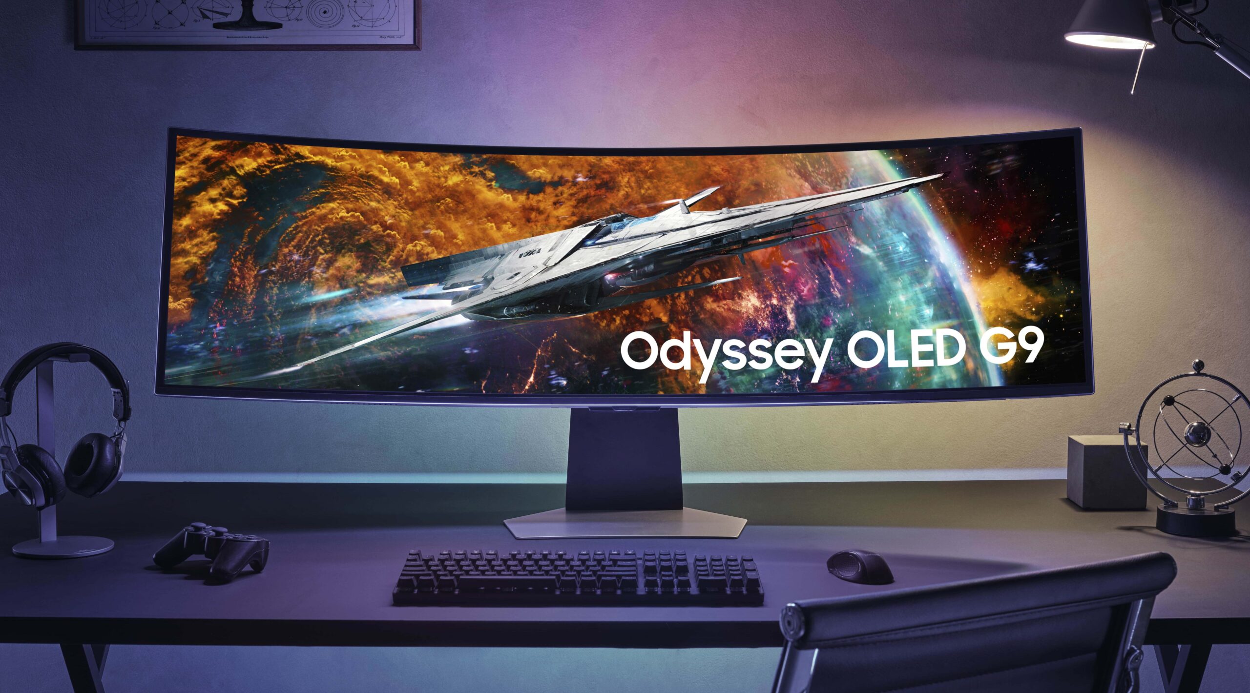 Zakrzywiony monitor Samsung Odyssey OLED G9 na biurku z klawiaturą, myszką, słuchawkami i kontrolerem do gier.