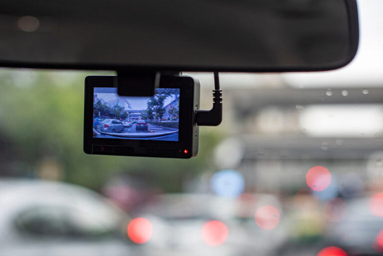 Kamera samochodowa zarejestrująca widok zakorkowanej ulicy.