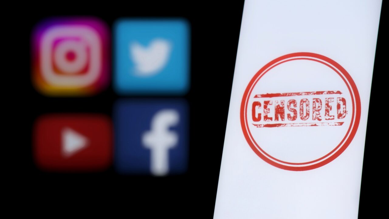 Cztery rozmyte ikony mediów społecznościowych (Instagram, Twitter, YouTube, Facebook) oraz biały ekran z symbolem cenzury.