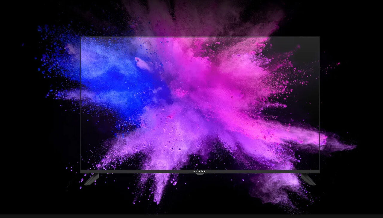 Czarny telewizor 4k na tle kolorowych wybuchów proszku w odcieniach niebieskiego i fioletowego.