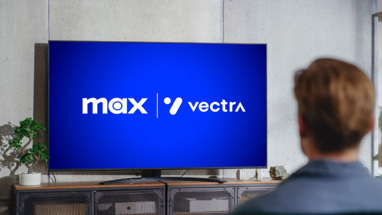 Osoba oglądająca telewizor z logo Max i Vectra na ekranie.
