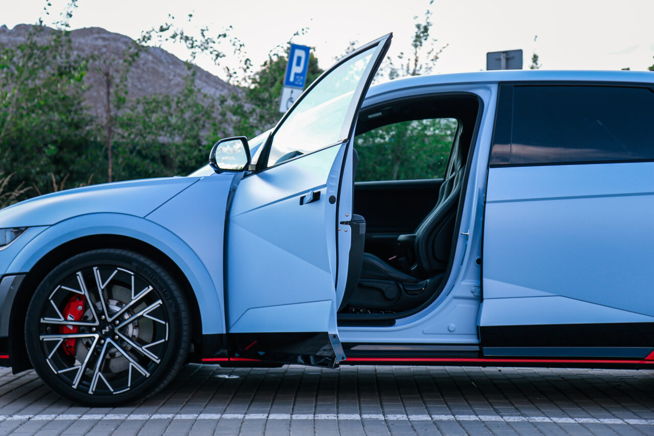 Błękitny samochód Hyundai Ioniq 5 N z otwartymi drzwiami na parkingu – test Hyundai Ioniq 5 N.