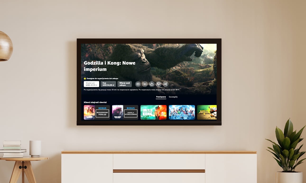 Telewizor na ścianie z widokiem na ekranie przedstawiającym ofertę filmu "Godzilla i Kong: Nowe imperium" i podobne rekomendacje.