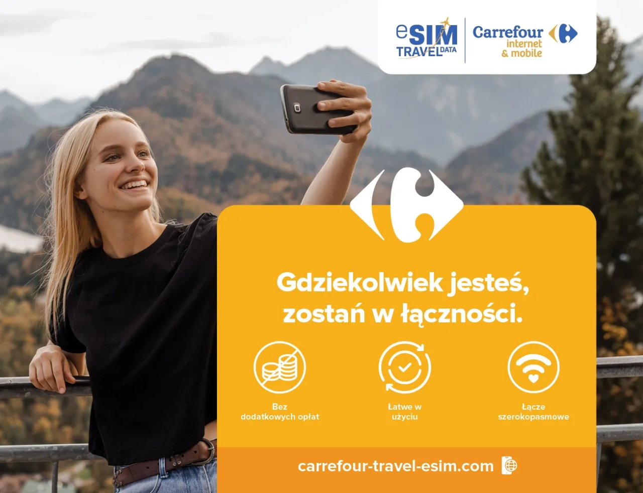 eSIM Travel Data. Kobieta robiąca sobie selfie na tle gór z napisem "Gdziekolwiek jesteś, zostań w łączności" i logiem Carrefour.