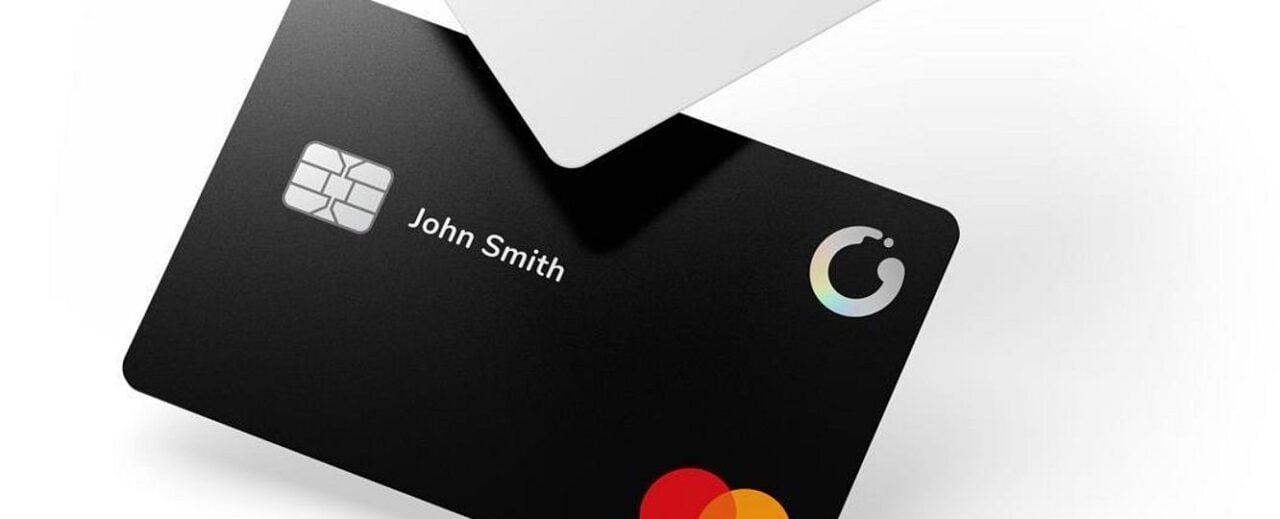 Czarna karta płatnicza z chipem i napisem "John Smith" oraz logo Mastercard.