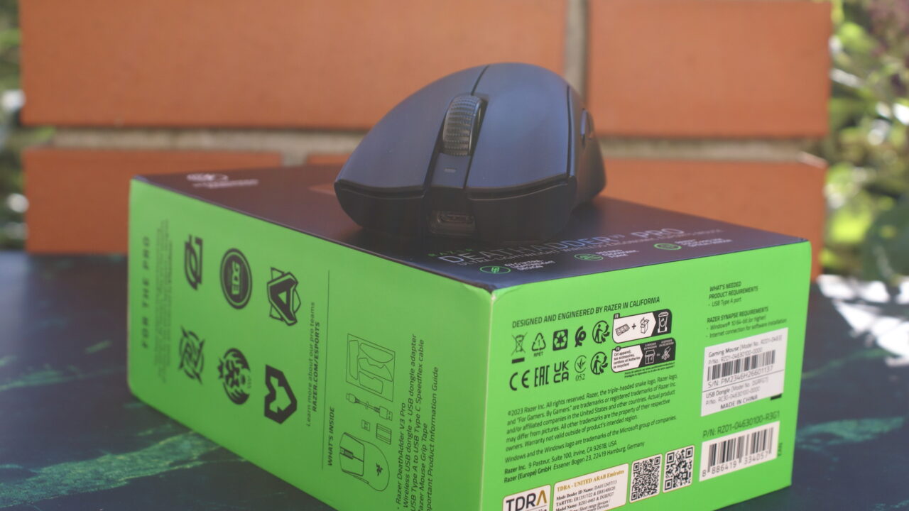 Bezprzewodowa myszka gamingowa Razer Deathadder V3 Pro na opakowaniu na tle ceglanej ściany.