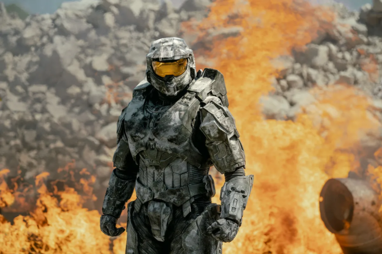 Kadr z serialu Halo. Postać w futurystycznym zbrojonym skafandrze na tle eksplozji i płomieni.