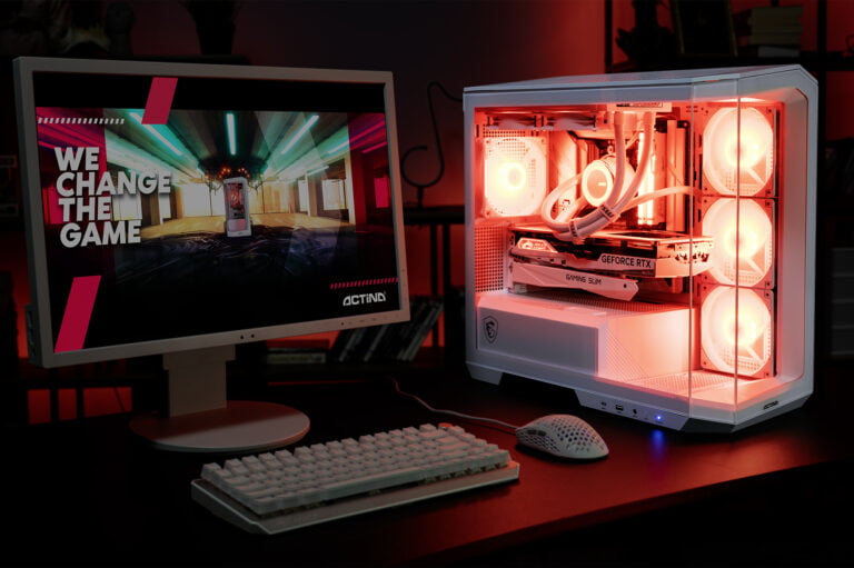 Komputer stacjonarny ACTINA powered by MSI z podświetleniem RGB oraz biały monitor wyświetlający napis „We Change The Game” i biały zestaw klawiatury z myszką na biurku.