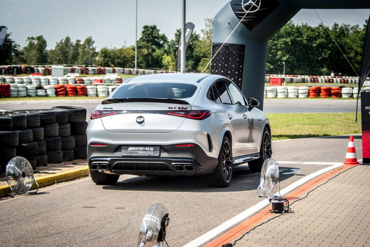 Srebrny samochód Mercedes-Benz GLC 63s AMG na torze wyścigowym.