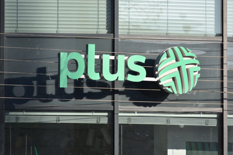 Logo Plus na szklanym budynku.