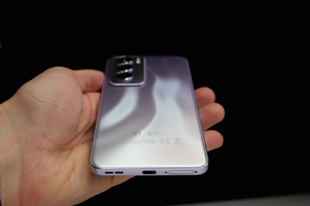 Fioletowy smartfon w ręce, widok od tyłu, z widocznym logo "oppo" oraz modułem aparatu.