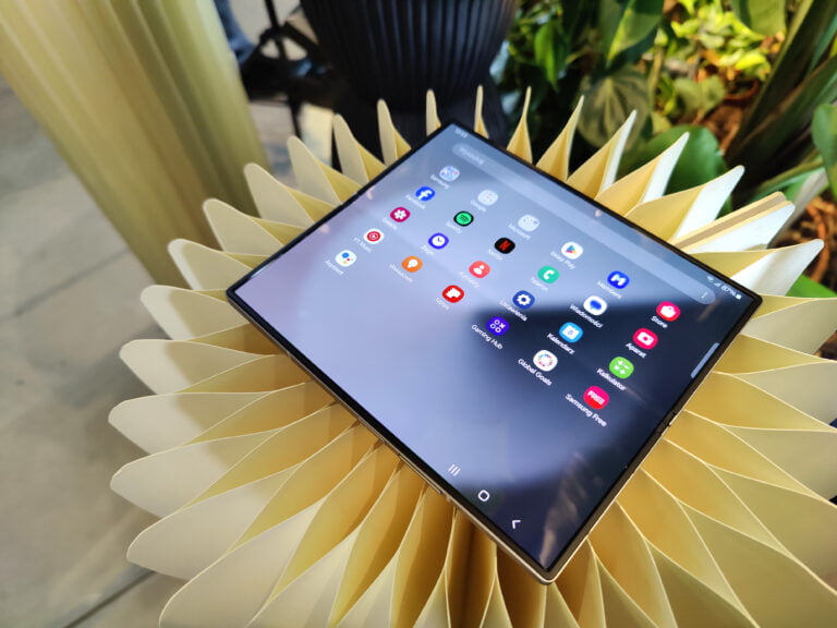 Nowości w portfolio Samsunga. Rozłożony smartfon Samsung Galaxy Z Fold6 z aplikacjami na ekranie, leżący na dekoracyjnym elemencie w kształcie kwiatka.