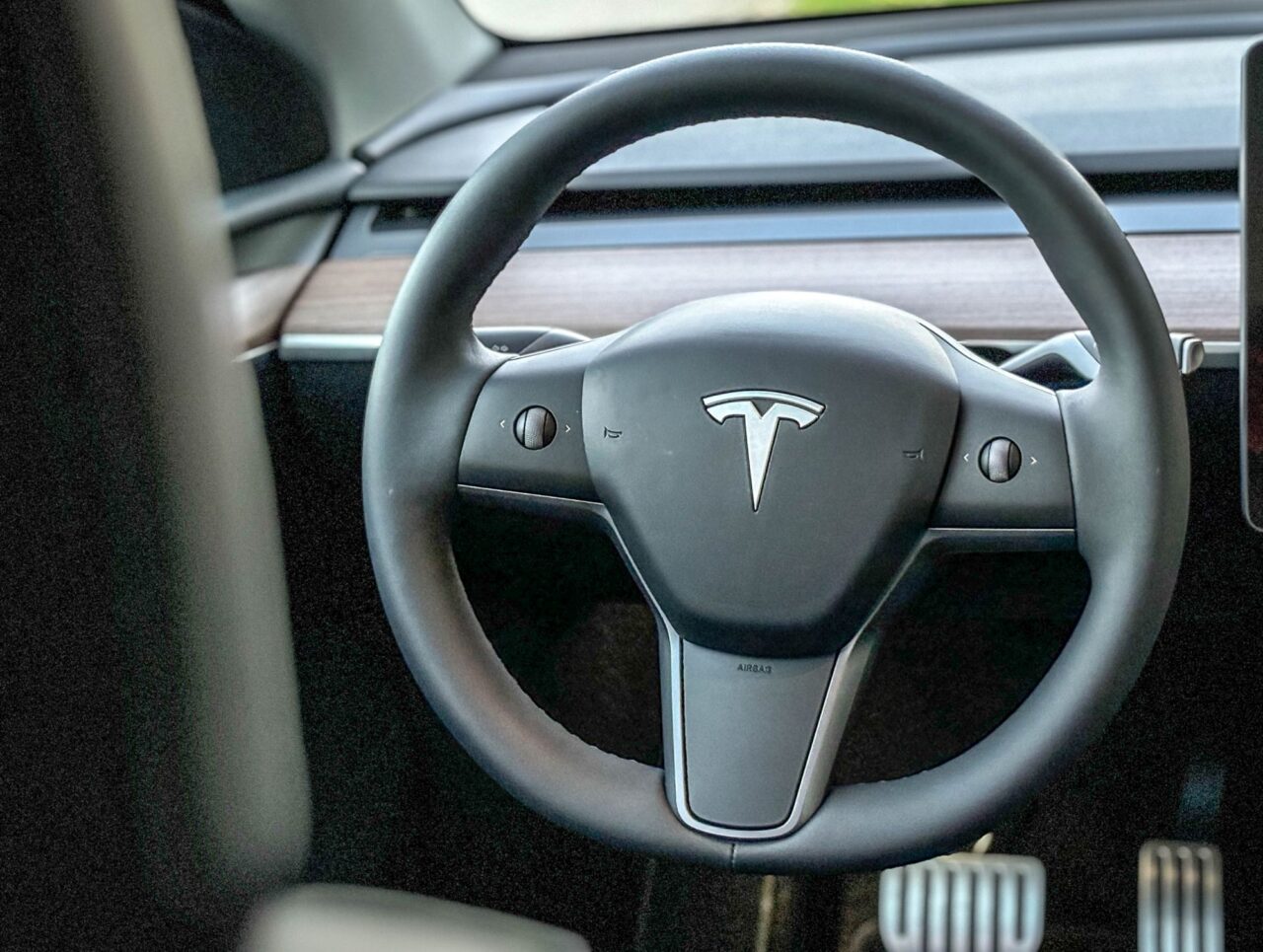 Wnętrze samochodu Tesla Model Y Performance z widokiem na kierownicę.