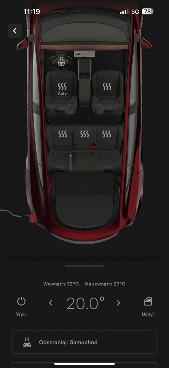 Widok wnętrza Tesli Model Y Performance z włączonym ogrzewaniem siedzeń i kierownicy, temperatura wewnętrzna 32°C, zewnętrzna 27°C, ustawiona temperatura 20°C, opcja odmrażania samochodu.
