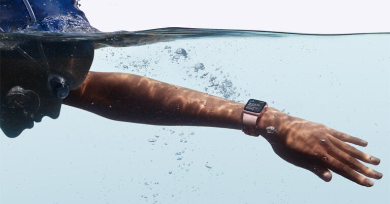 Osoba pływająca pod wodą z zegarkiem na ręku.
