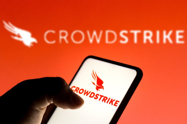 Logo CrowdStrike na ekranie telefonu na tle większego logo CrowdStrike.